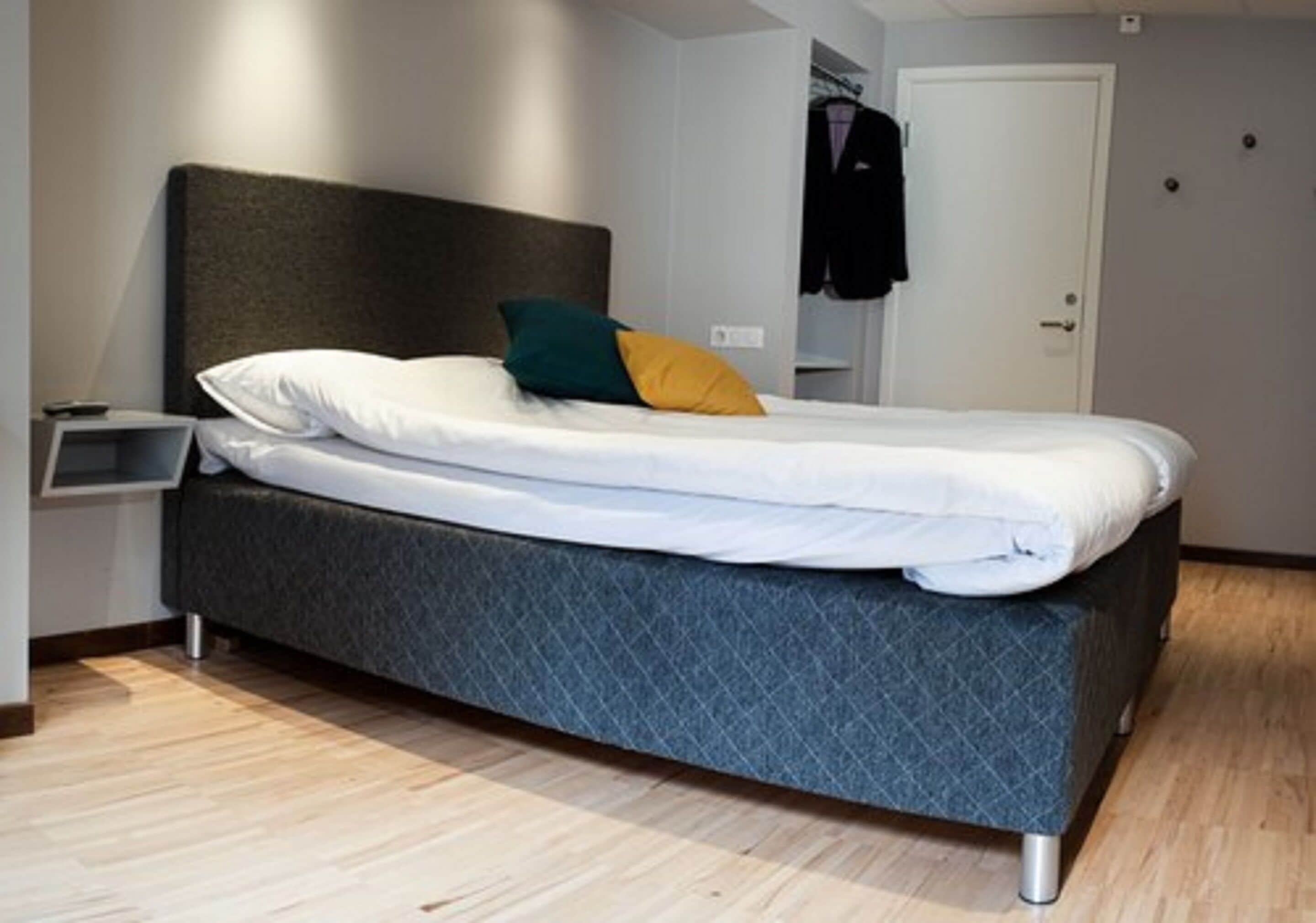 Un dormitorio moderno con cama, mesita de noche y armario.