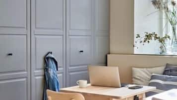 A modern kitchen with a wooden table, chairs, and a laptop.