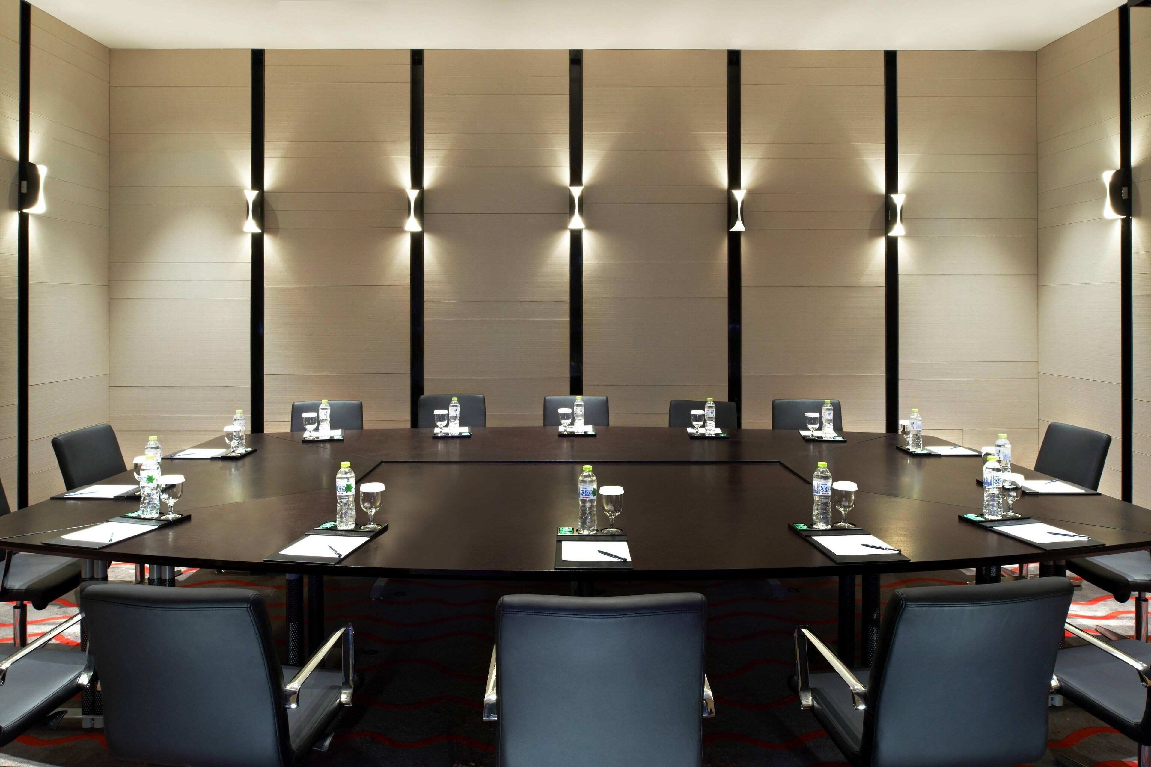 A conference room with a large table, chairs, water bottles, and nameplates.