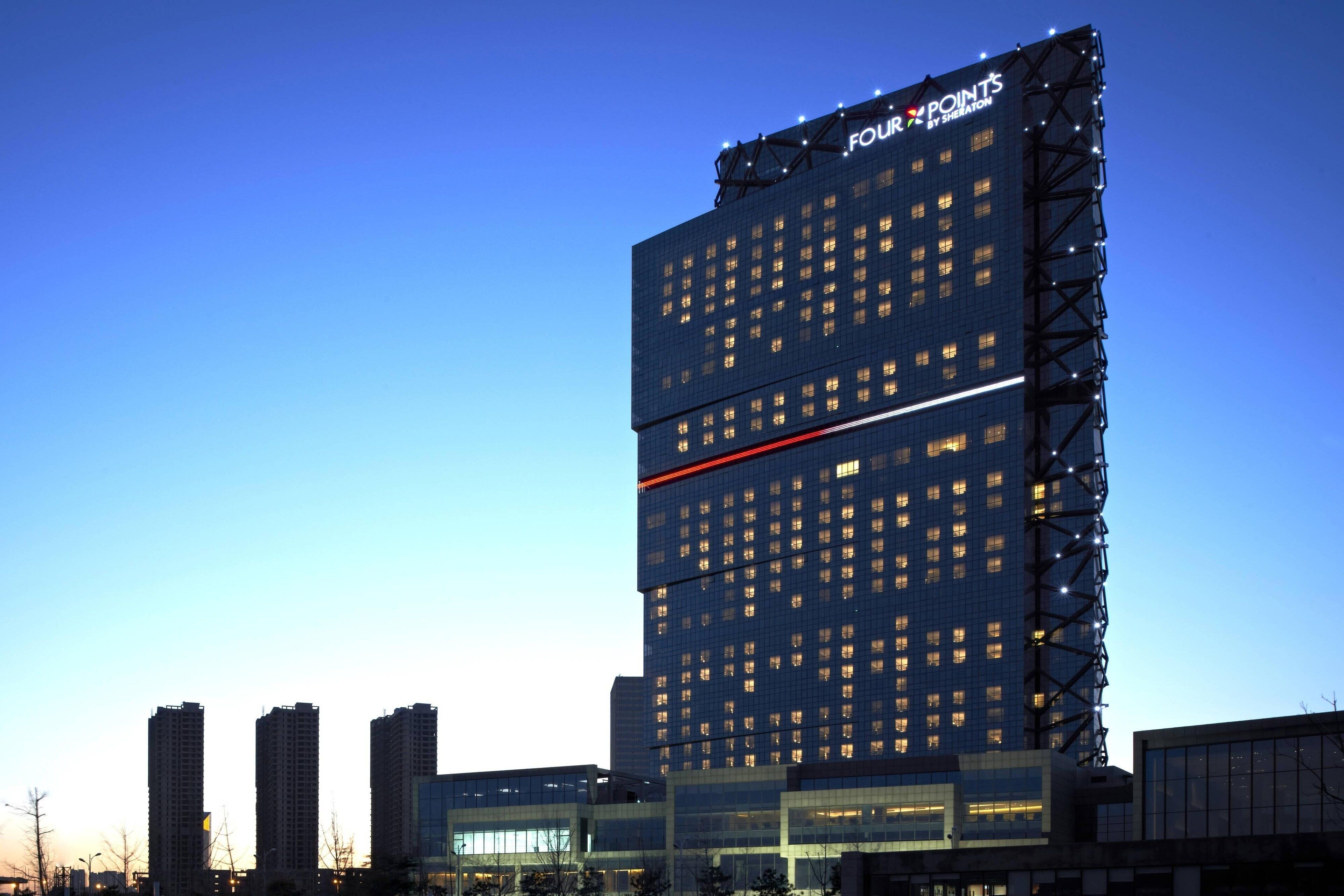 A high-rise hotel with multiple floors, a prominent sign at the top, and a modern architectural design.