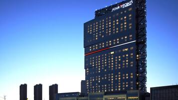 A high-rise hotel with multiple floors, a prominent sign at the top, and a modern architectural design.