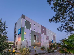 A modern hotel building with multiple floors, large windows, and a sign indicating it is part of the ibis budget hotel chain. - ibis budget Porto Gaia (Vila Nova de Gaia)