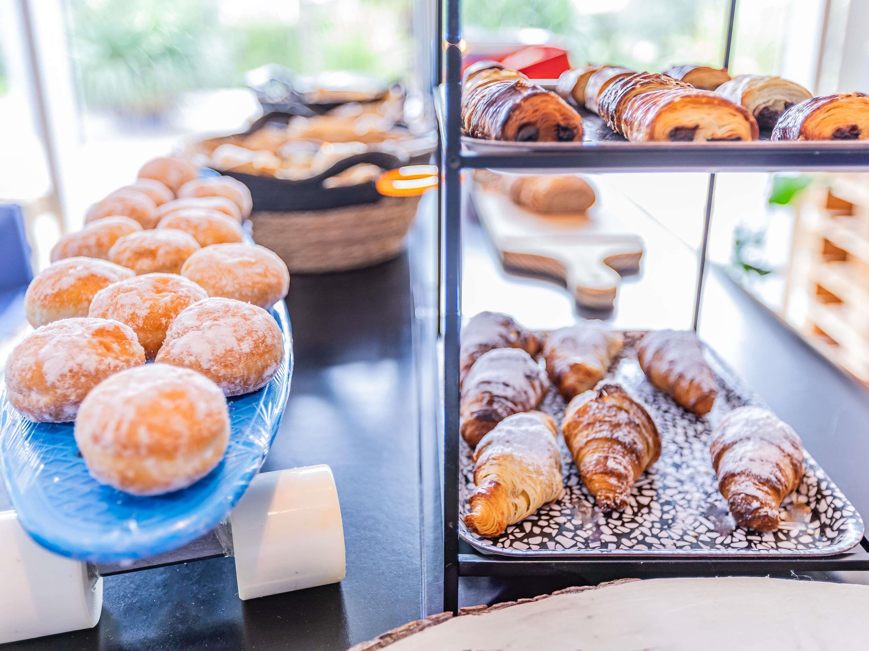 Vitrine de uma padaria com diversos doces e donuts.