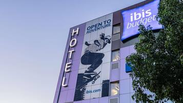 A hotel building with a sign reading "HOTEL" and "OPEN TO ADVENTURE".
