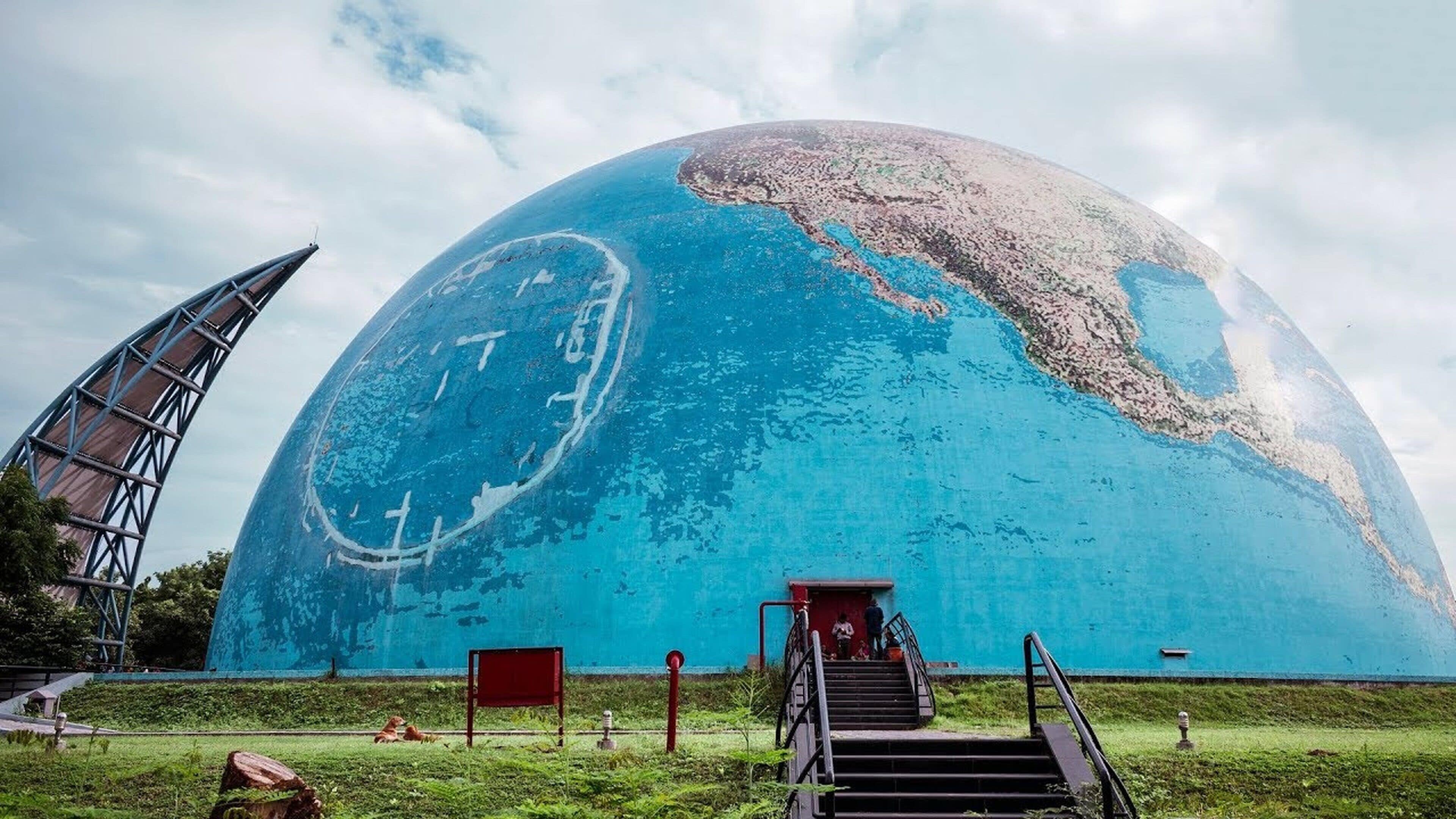 A large blue dome structure with a staircase leading up to a platform.