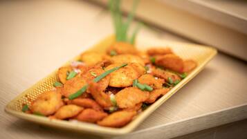 A rectangular plate with fried food items garnished with green herbs.