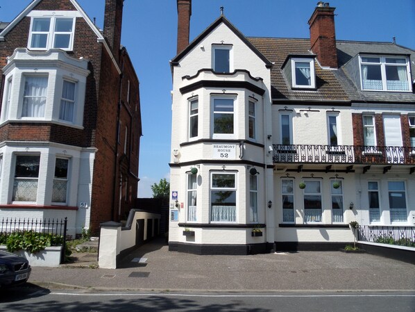 A row of traditional British terraced houses with a prominent 'Beaumont House' sign. - Beaumont House (Great Yarmouth)