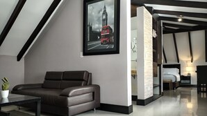 Een moderne woonkamer met een bruine leren bank, een glazen salontafel en een lijst met een foto van een rode dubbeldekkerbus.