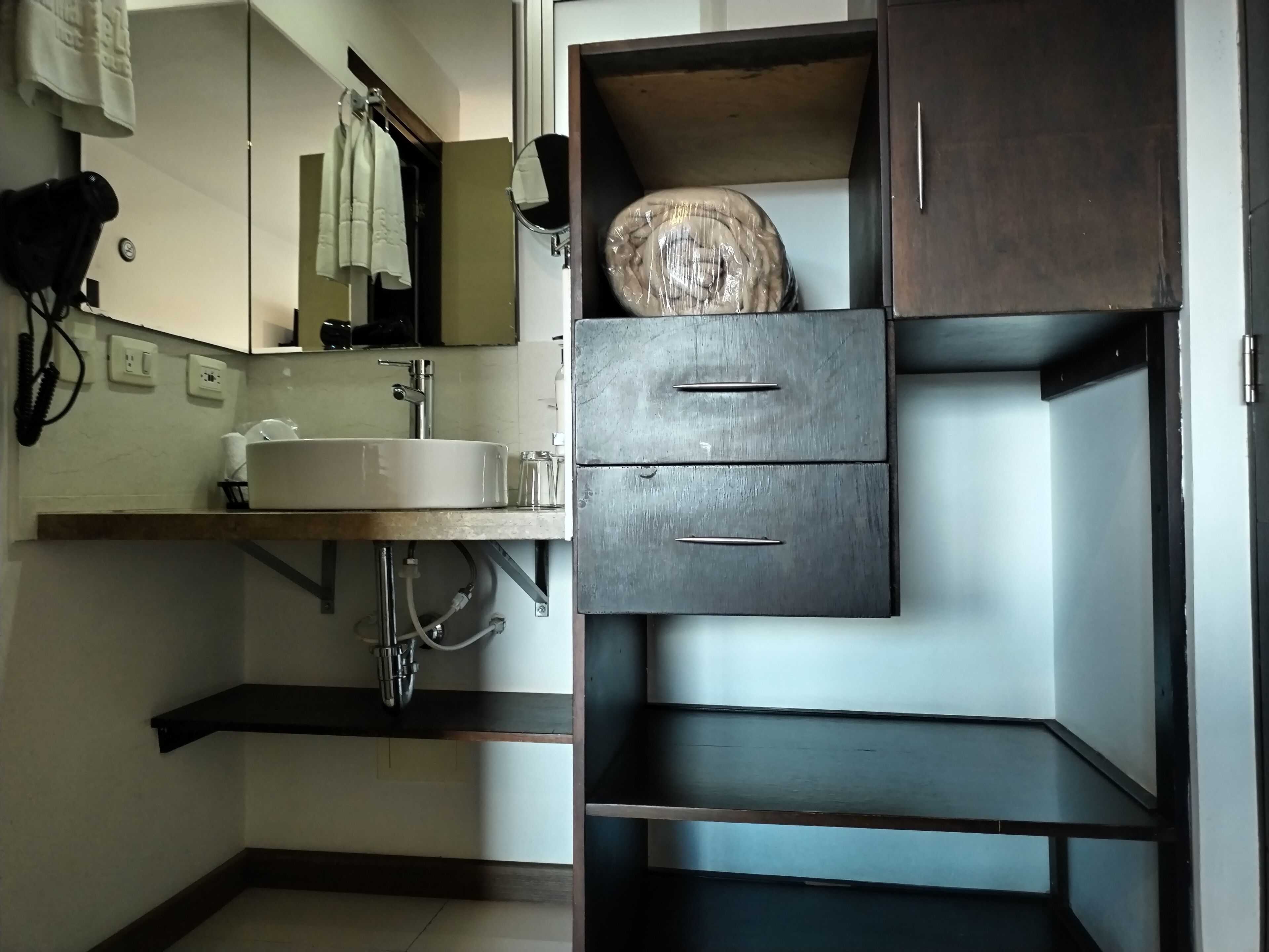 A bathroom with a sink, mirror, and a cabinet with a round object on top.