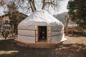 Una yurta con puerta de madera y un pequeño porche.