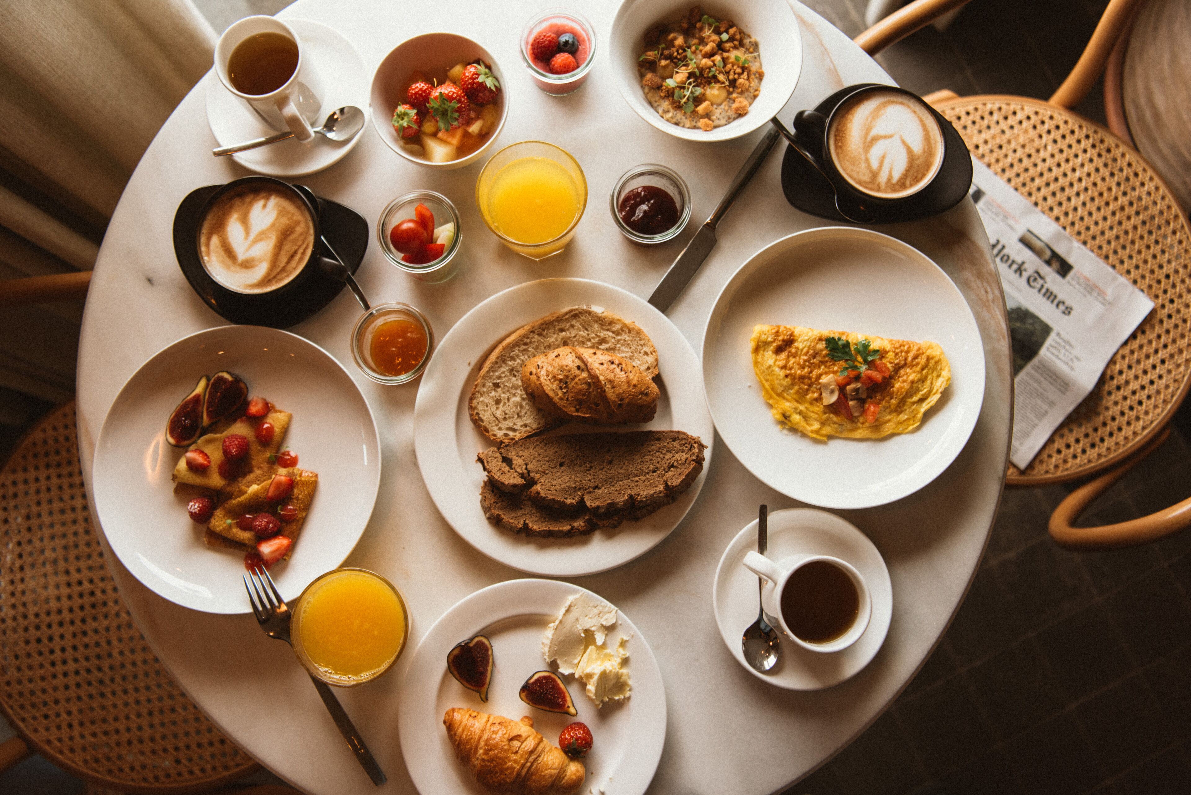 Une table de petit-déjeuner avec divers aliments et boissons.