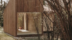 A wooden cabin with a small porch and a potted plant. - Hotel Schwarzschmied (Lana)