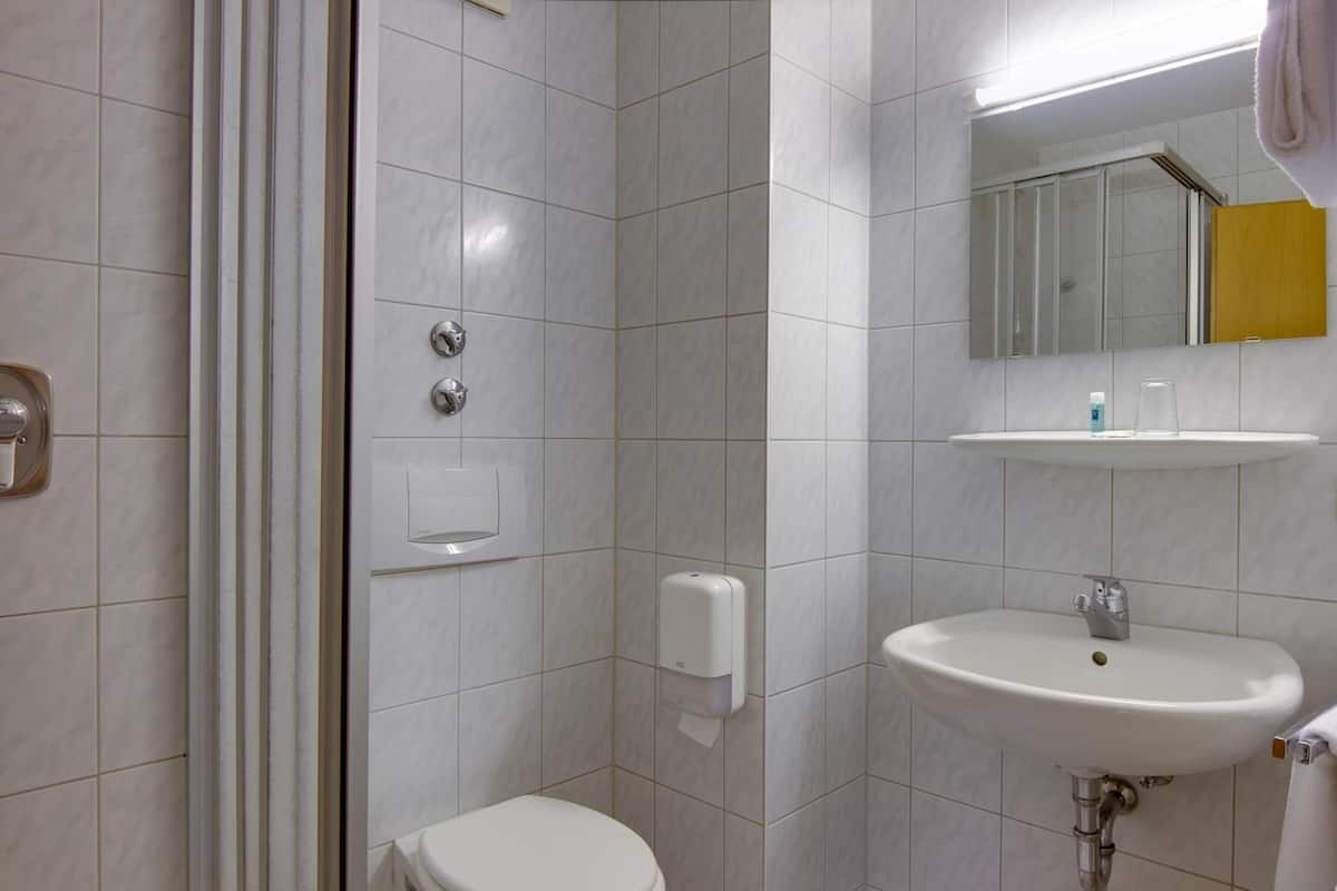 Kylpyhuone, jossa on wc, pesuallas, peili ja suihku.