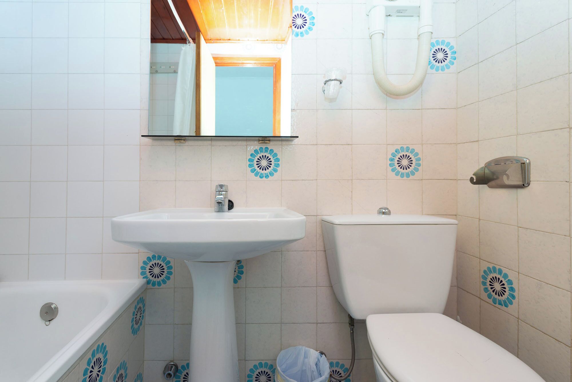 A bathroom with a pedestal sink, toilet, and bathtub.