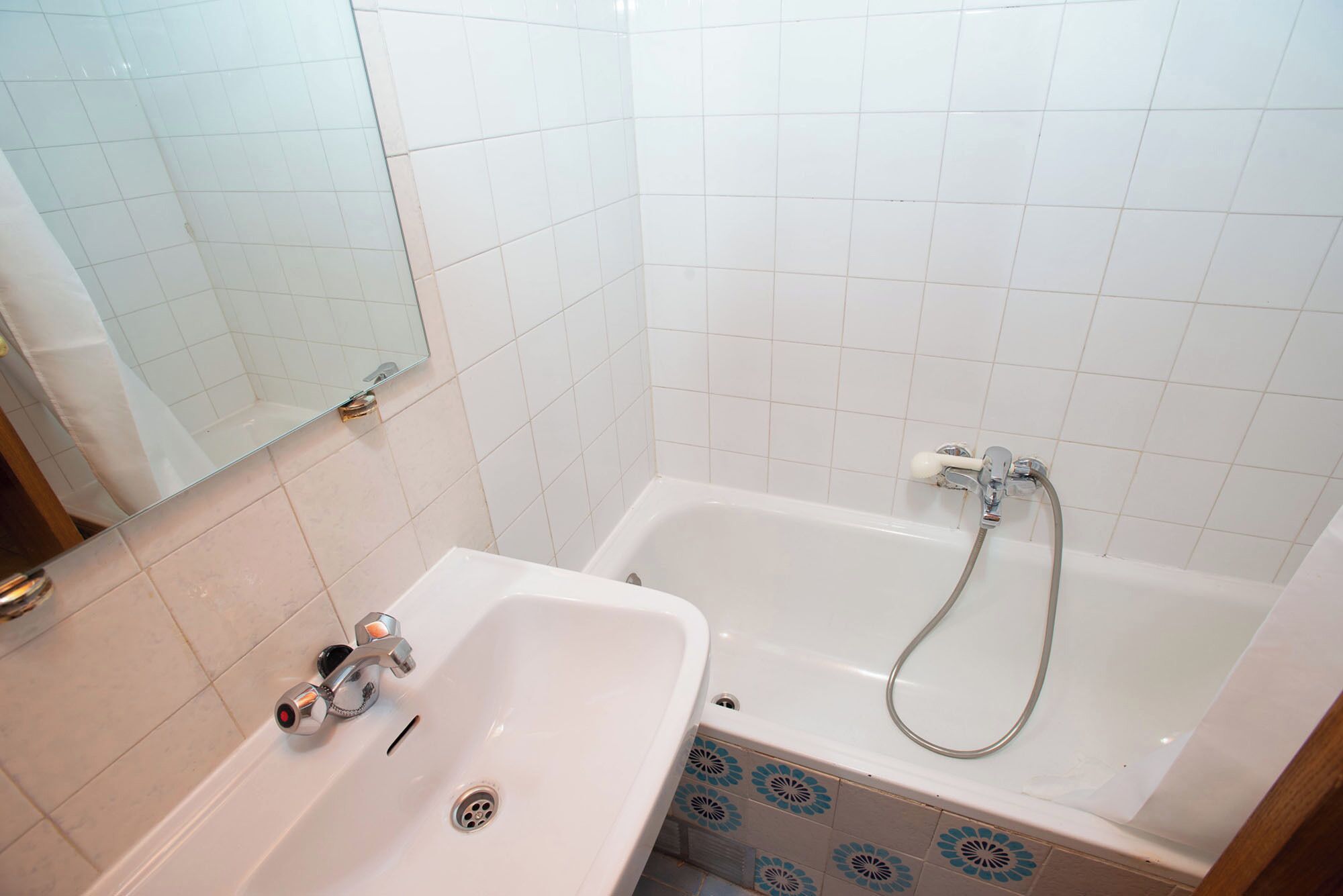 A bathroom with a white sink, a bathtub, and a shower.