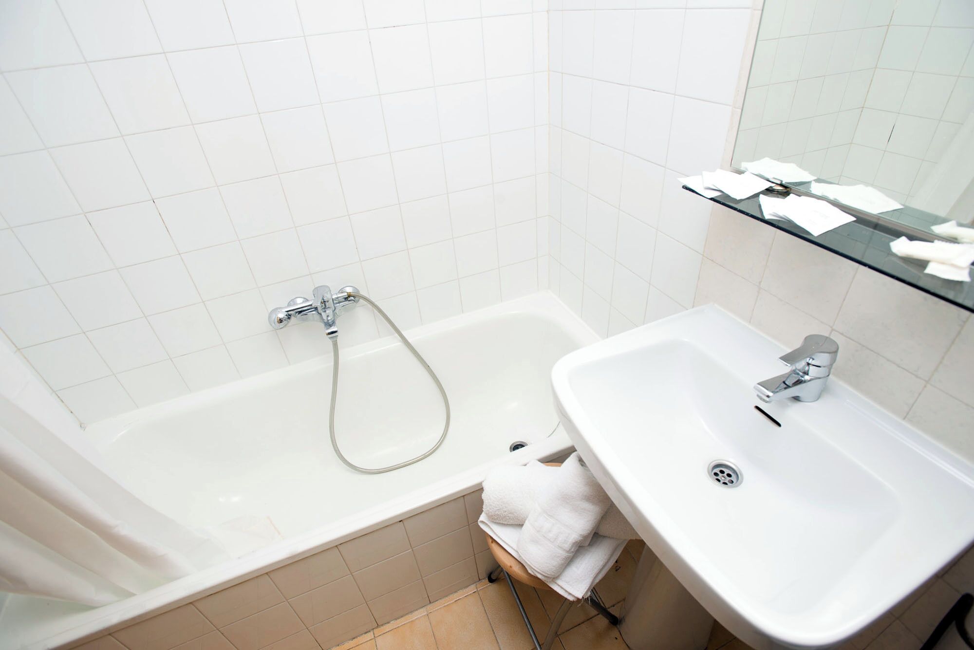 A bathroom with a bathtub, a sink, and a towel rack.