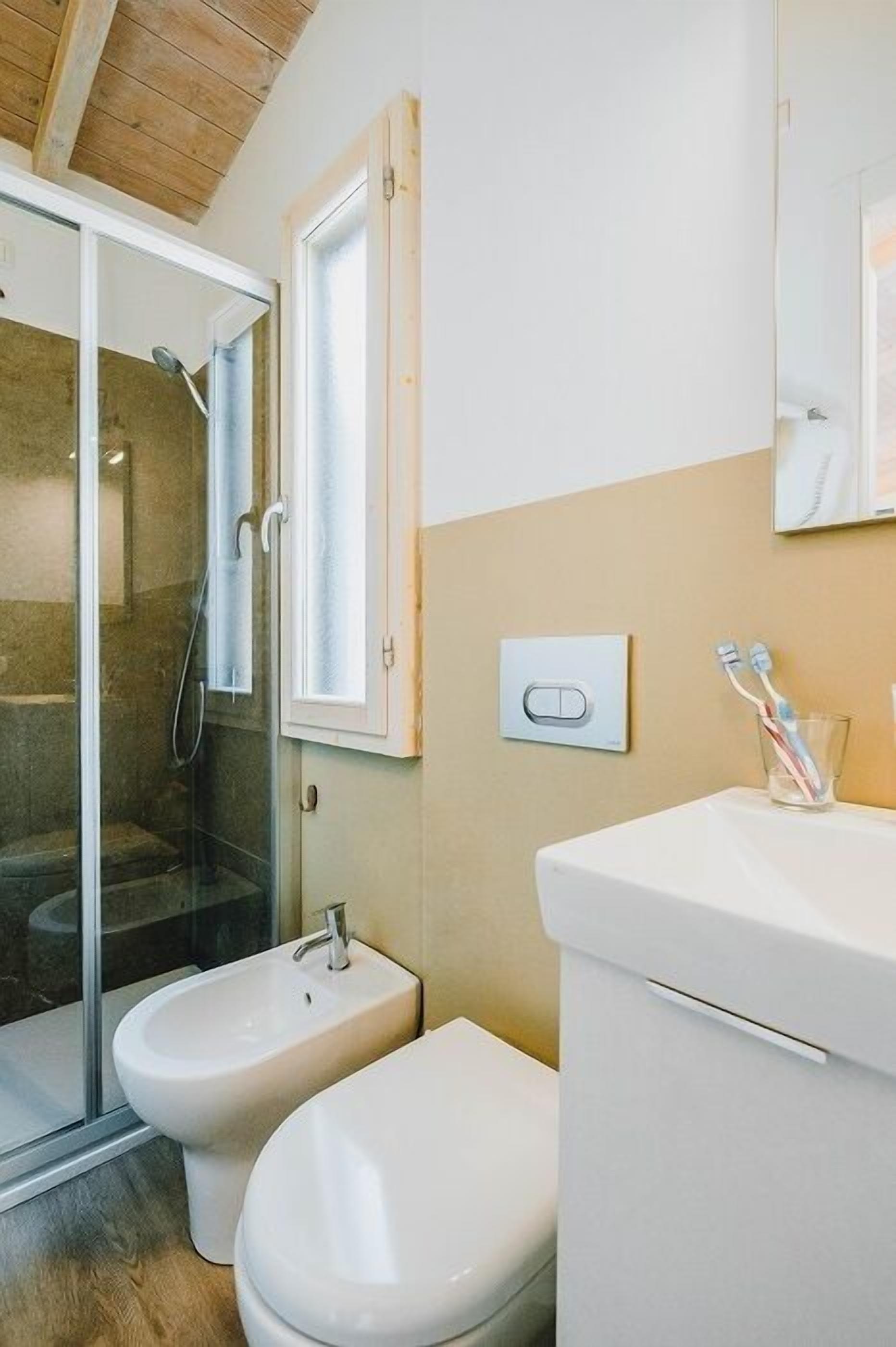 Un bagno compatto con box doccia, bidet e WC.