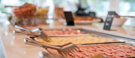 Un buffet proposant une variété de plats et d’ustensiles de service.