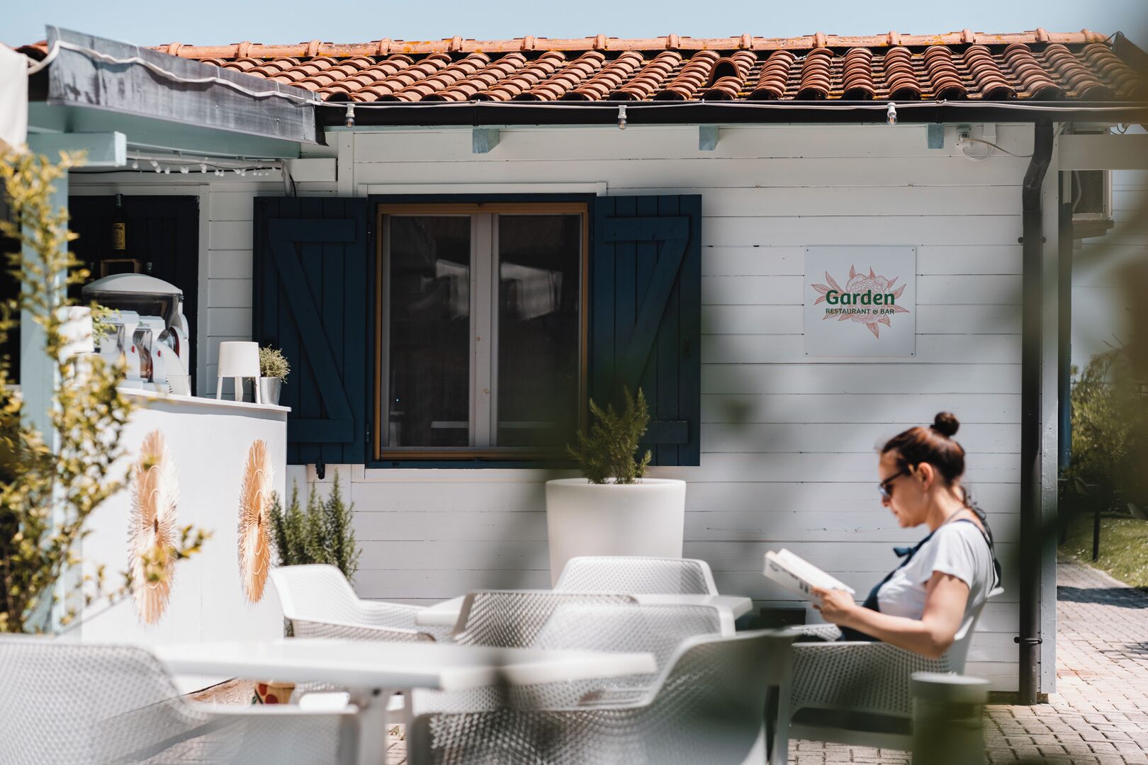 Un restaurante llamado 'Garden' con terraza y techo de baldosas.