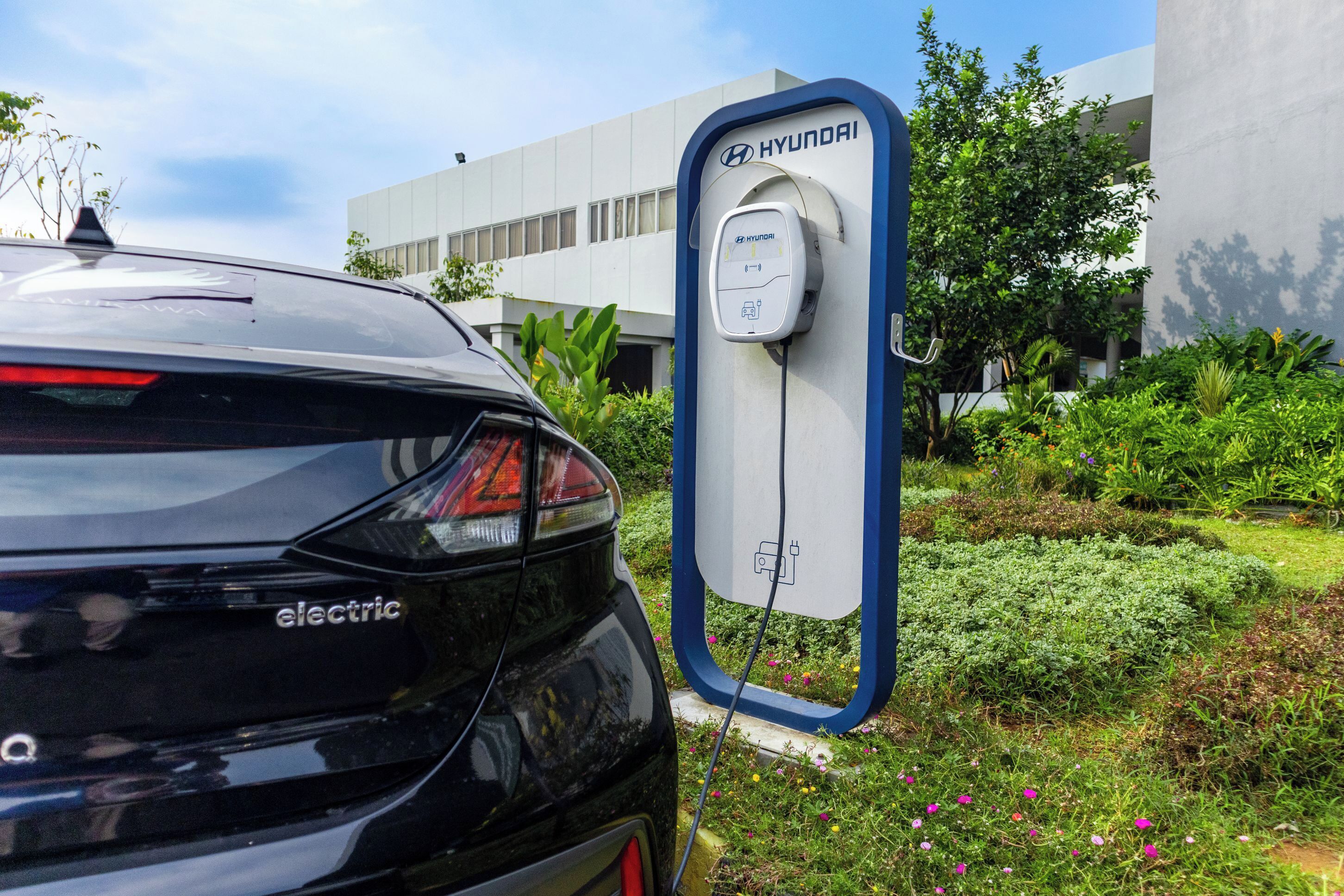 A black electric Hyundai car parked at a charging station.