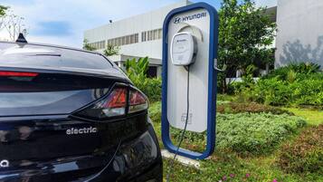 A black electric Hyundai car parked at a charging station.