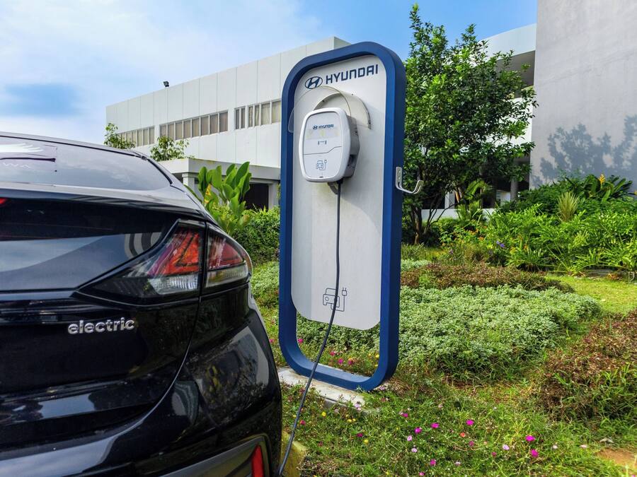 A black electric Hyundai car parked at a charging station.