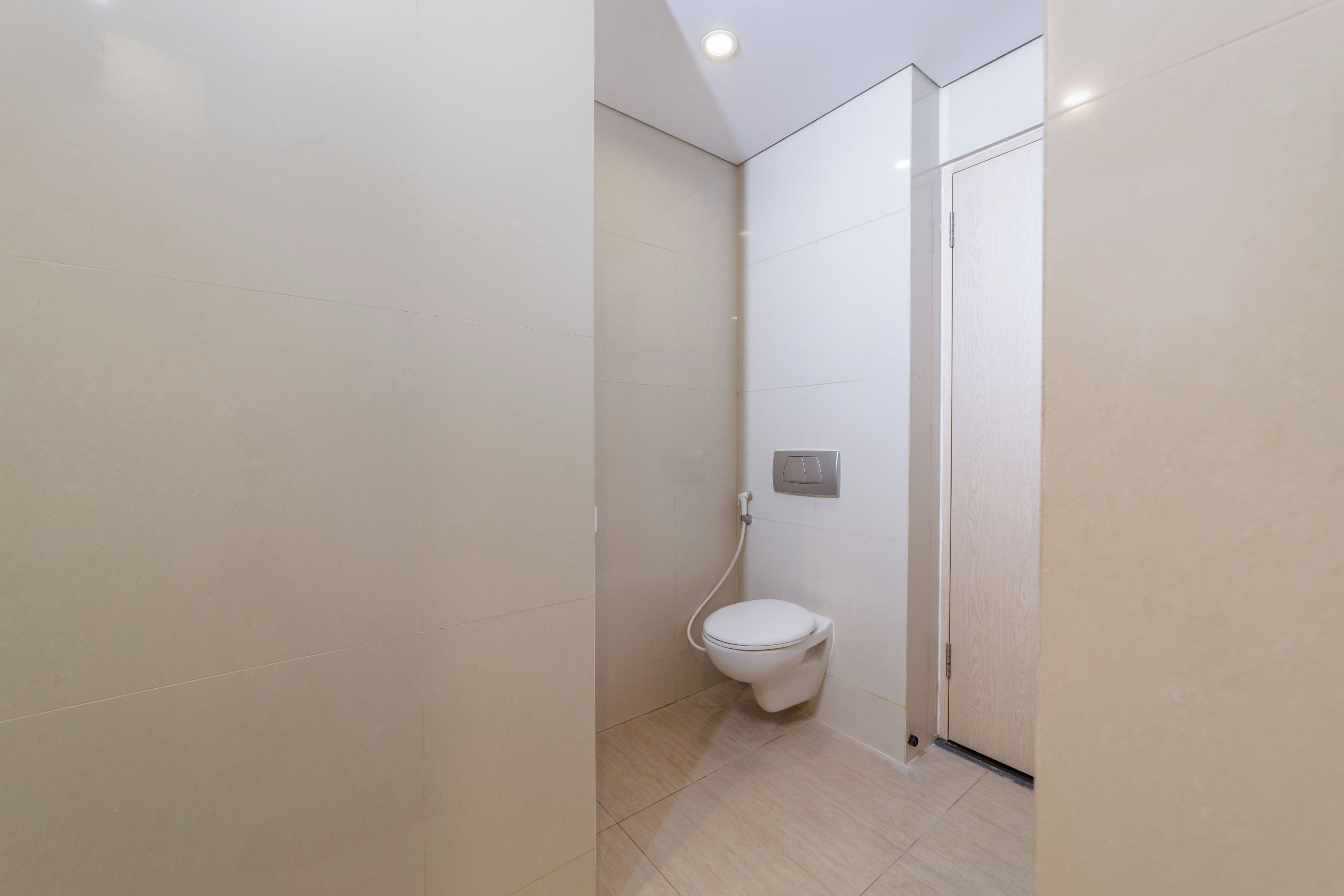 A modern bathroom with a toilet, a shower, and a toilet paper holder on the wall.