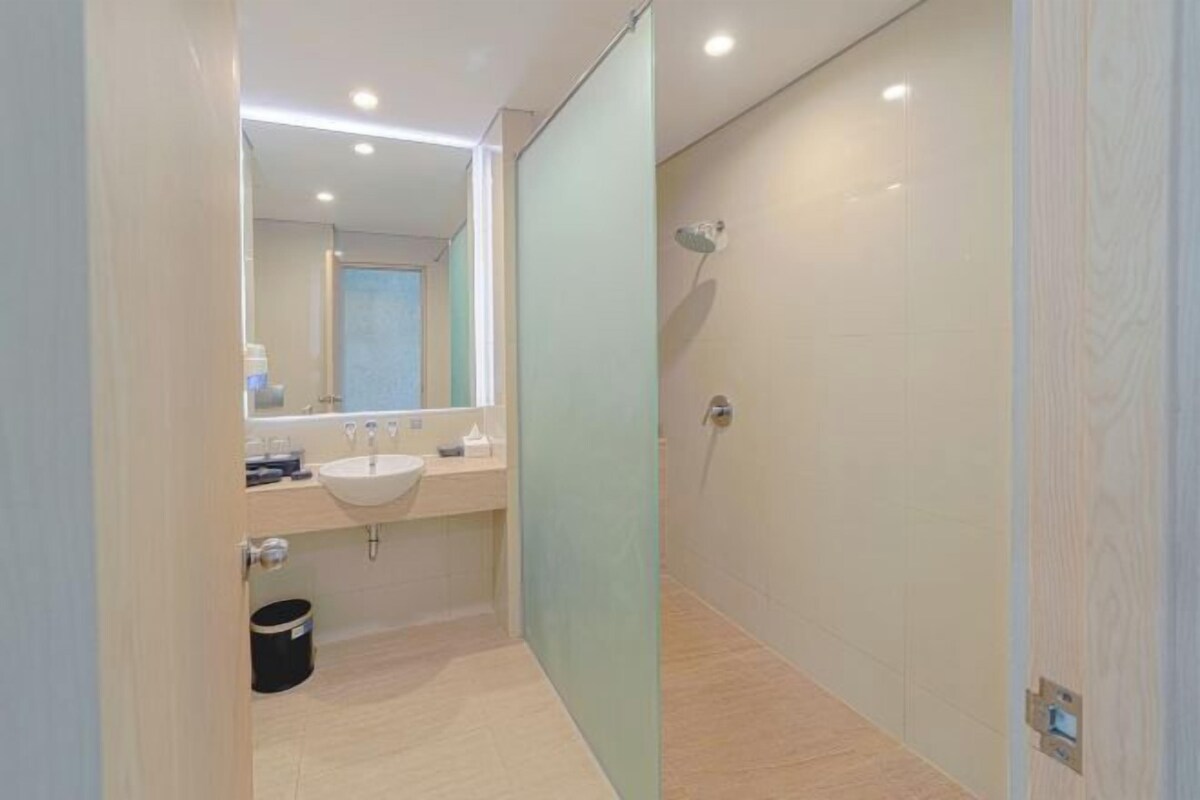 Une salle de bain moderne avec une paroi en verre, un lavabo et une douche.