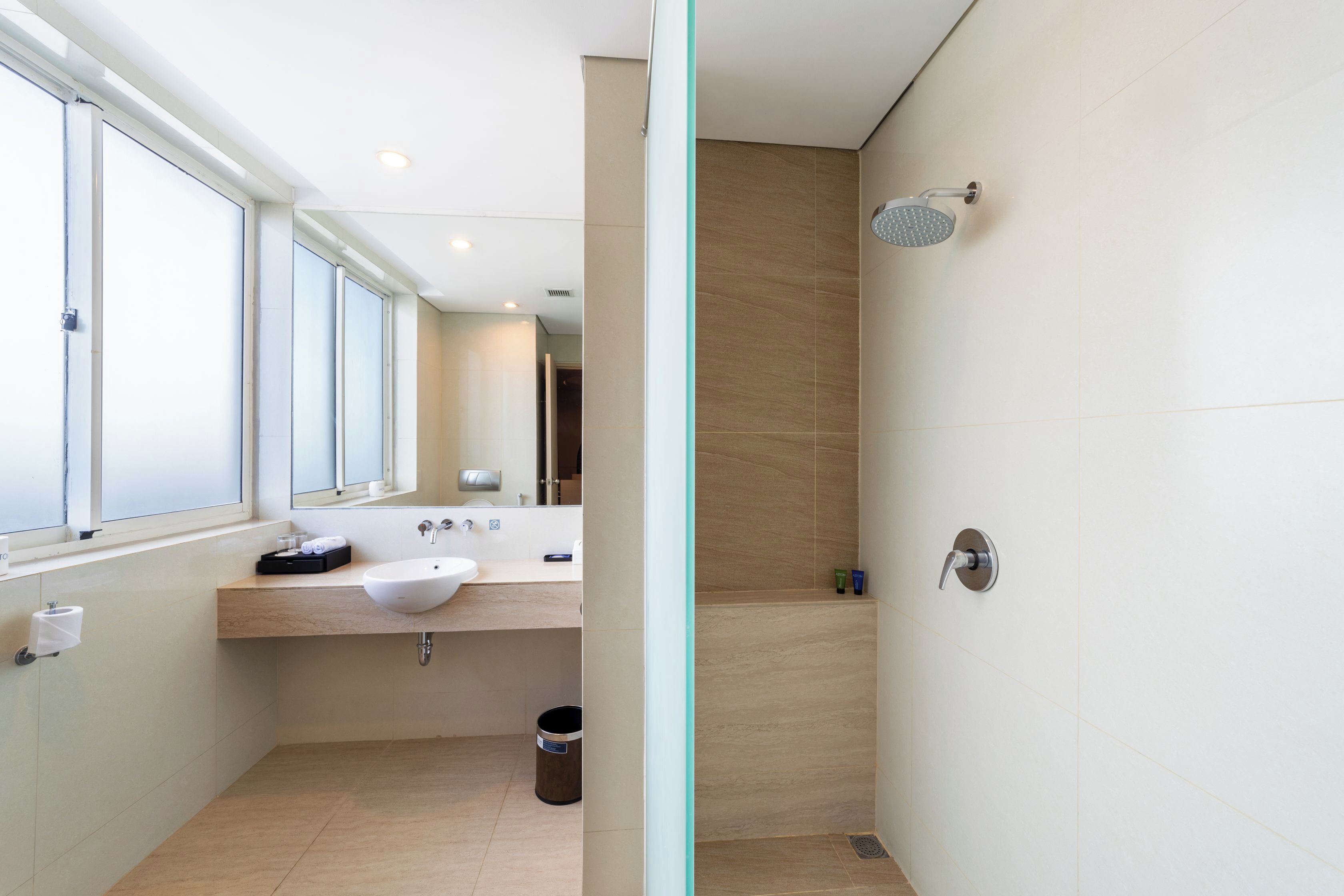 Un baño moderno con un ventanal grande, un lavabo y una ducha.
