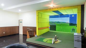 A modern office with a green sports field simulation, a reception desk, and a filing cabinet.