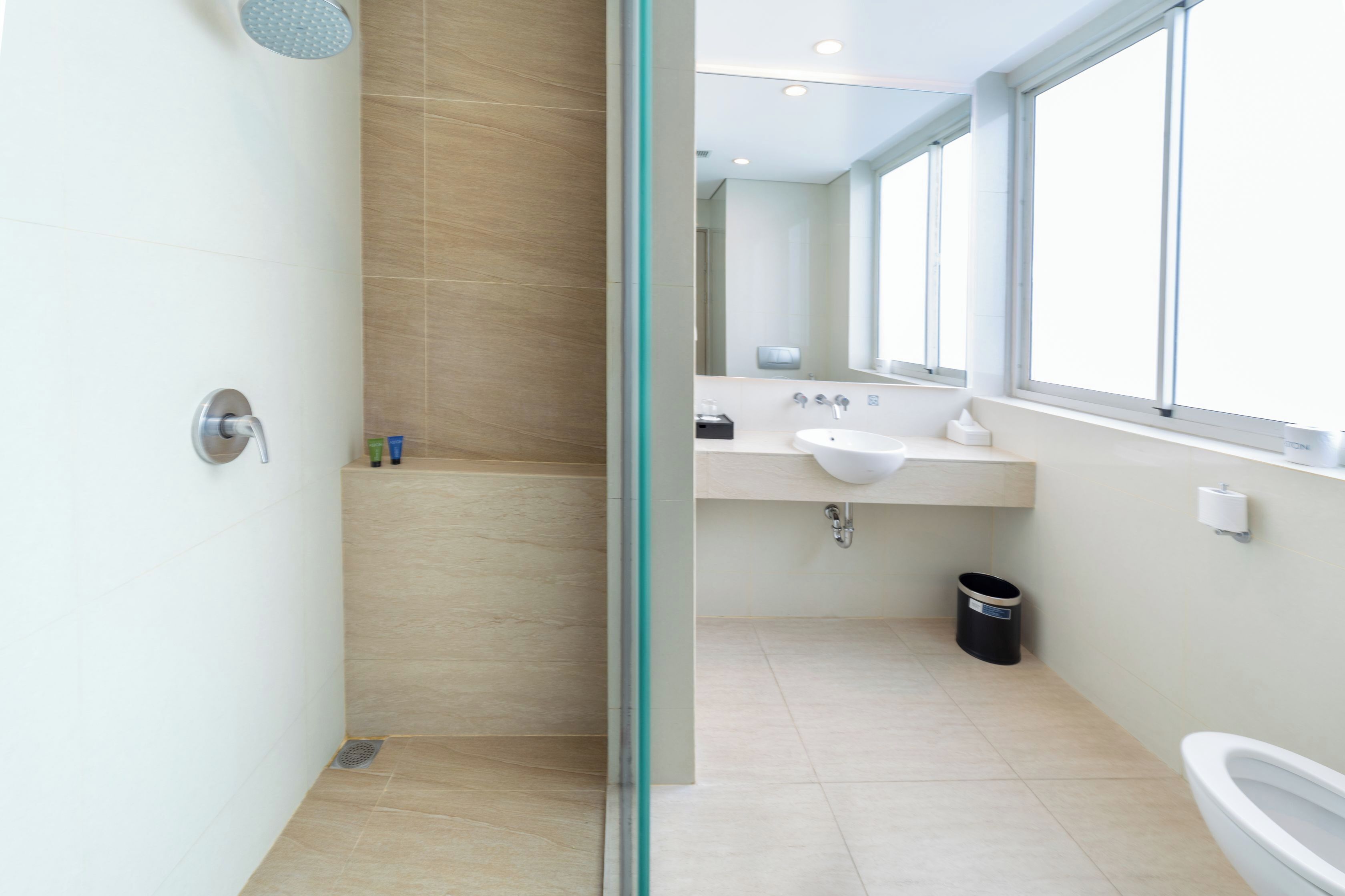 Een moderne badkamer met een douchecabine van glas, een wastafel en een toilet.