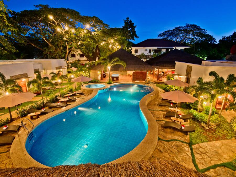 Een buitenzwembad, ligstoelen bij het zwembad