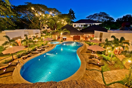 Una piscina al aire libre, sillones reclinables de piscina