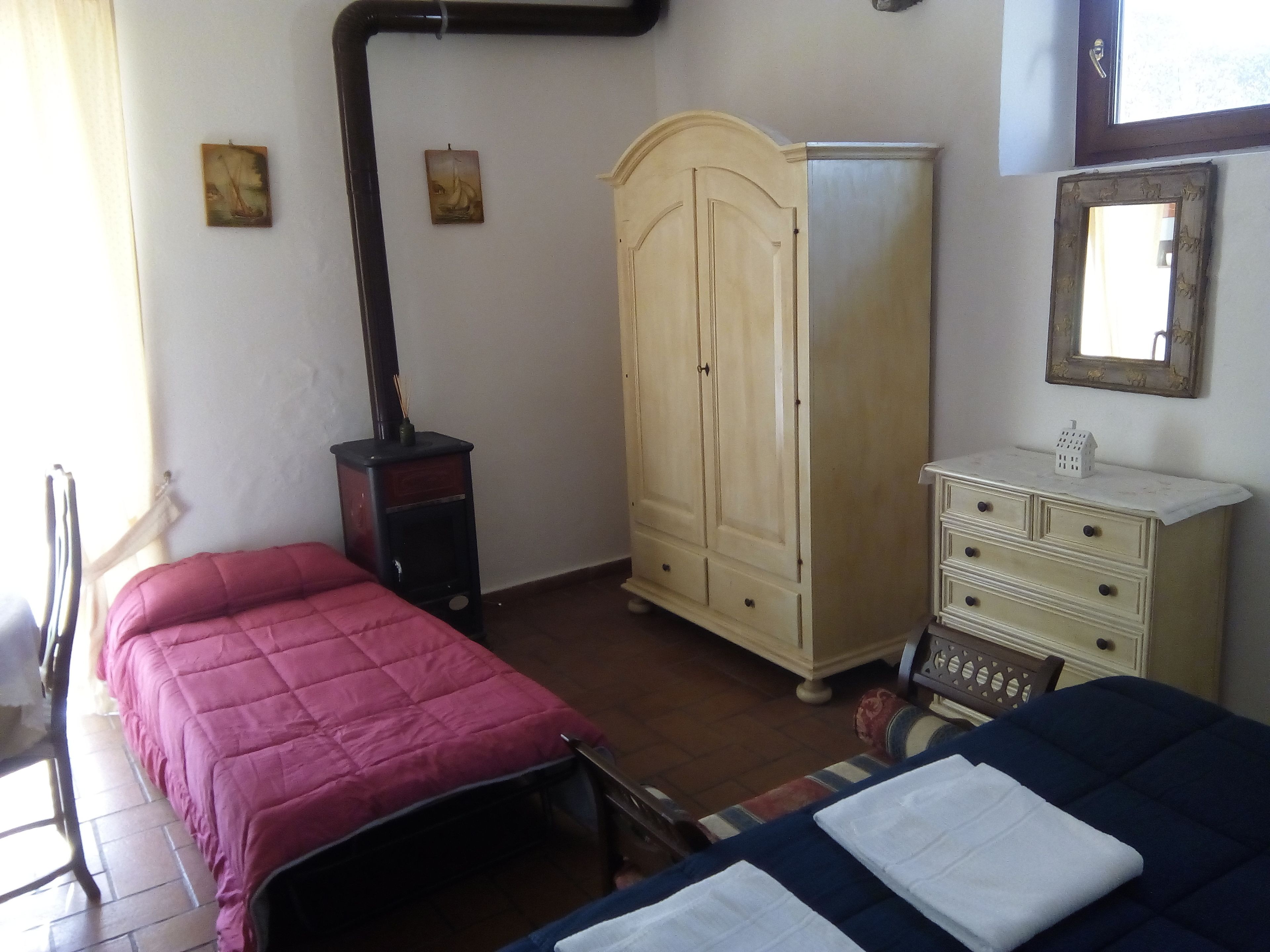 Un dormitorio con dos camas, un armario, un tocador, un calentador y un espejo.