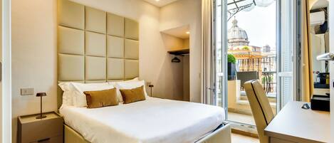 Een moderne hotelkamer met een groot bed, een bureau en een stadszicht door een groot raam.