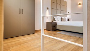 A modern bedroom with a bed, bedside table, and wardrobe. - Relais Badoer (Rome)