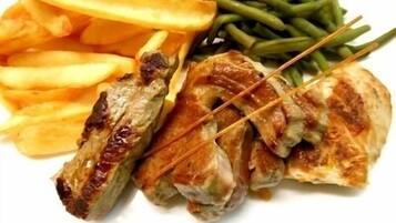 A plate with grilled chicken, French fries, and green beans.