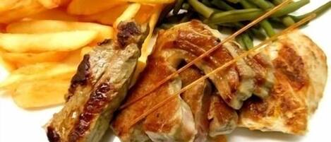 A plate with grilled chicken, French fries, and green beans.