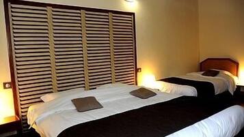 A hotel room with two beds, a wooden headboard, and bedside lamps.