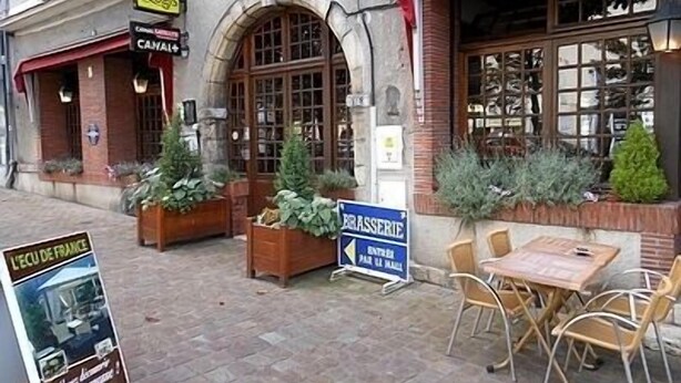 A restaurant with outdoor seating, a sign for 'L'ECO DE FRANCE', and a 'BRASSERIE' sign. - Hôtel de l'Ecu de France (Le Malesherbois)