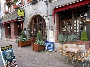 A restaurant with outdoor seating, a sign for 'L'ECO DE FRANCE', and a 'BRASSERIE' sign. - Hôtel de l'Ecu de France (Le Malesherbois)