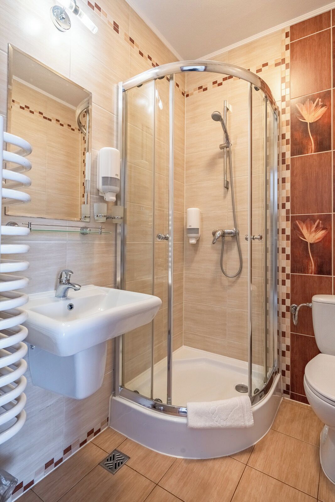 A modern bathroom with a glass-enclosed shower, a sink, and a toilet.