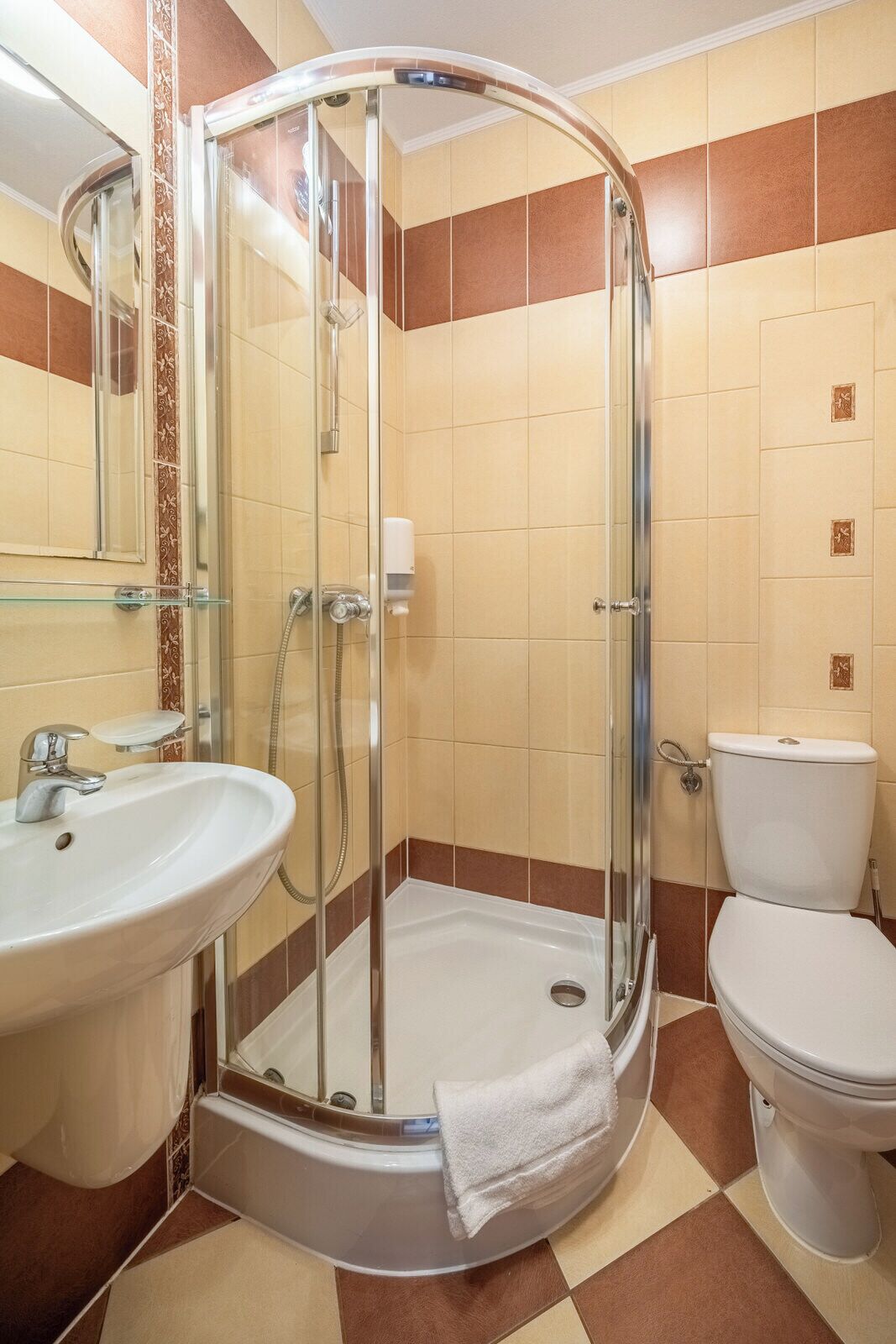 Un baño con ducha de vidrio, lavamanos e inodoro.