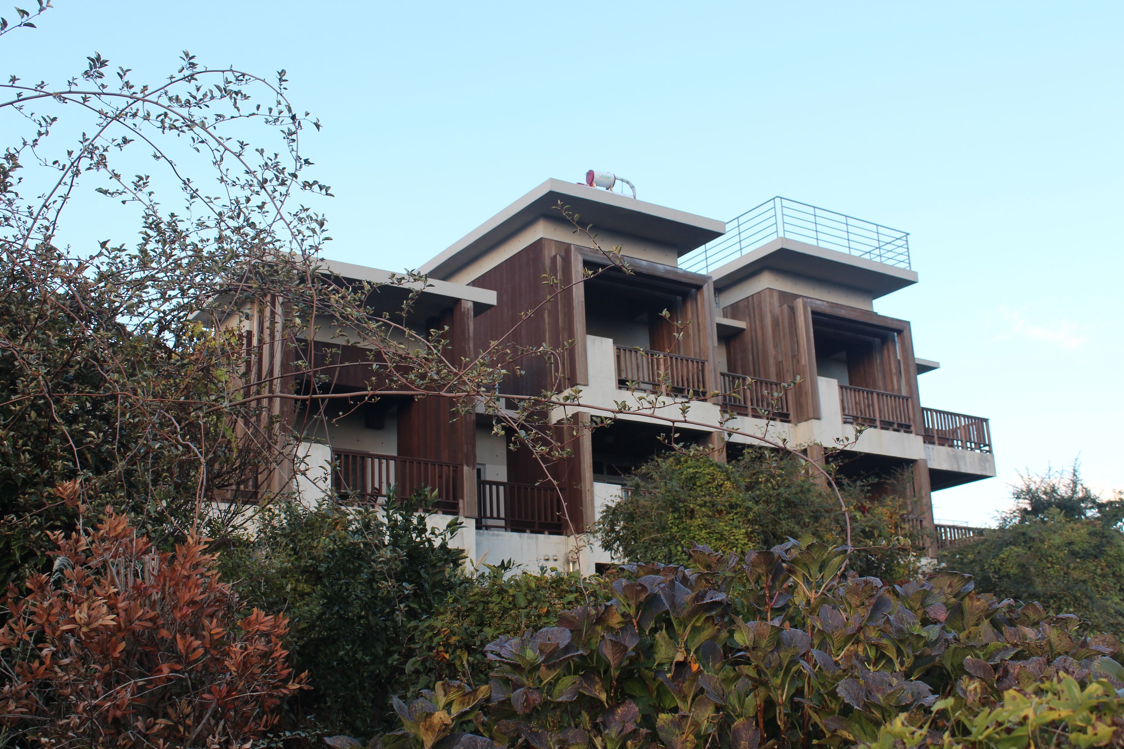 A multi-story building with balconies and a flat roof.