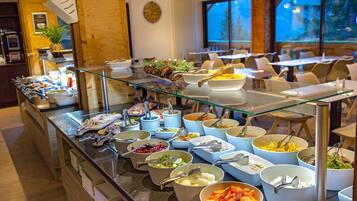 A buffet with various food items and utensils.