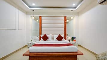 A modern bedroom with a wooden bed frame, white bedding, and a large mirror above the bed.