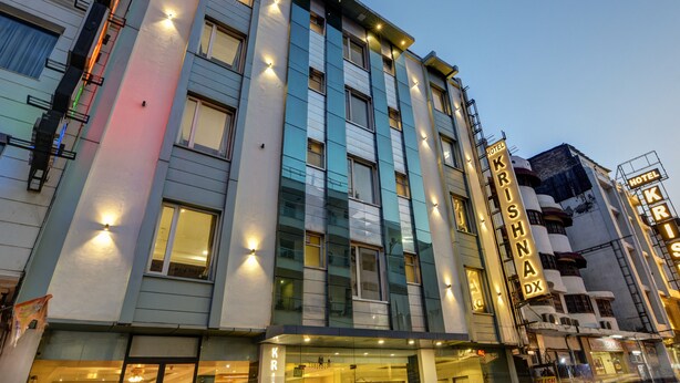 Un hotel de varios pisos con señalización iluminada, grandes ventanales y un diseño arquitectónico moderno.