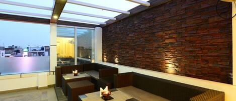 A rooftop bar with seating and a view of the cityscape.