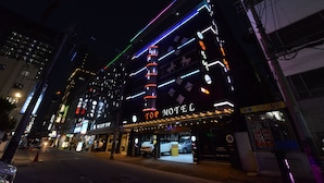 Un immeuble à plusieurs étages, sur lequel on peut voir une grande enseigne indiquant « Top Motel ».