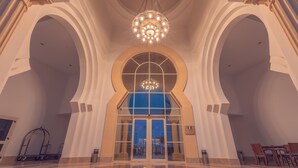 A grand lobby with a large arched entrance, a chandelier, and a reflective floor. - Old Palace Resort Sahl Hasheesh (Sahl Hasheeh)